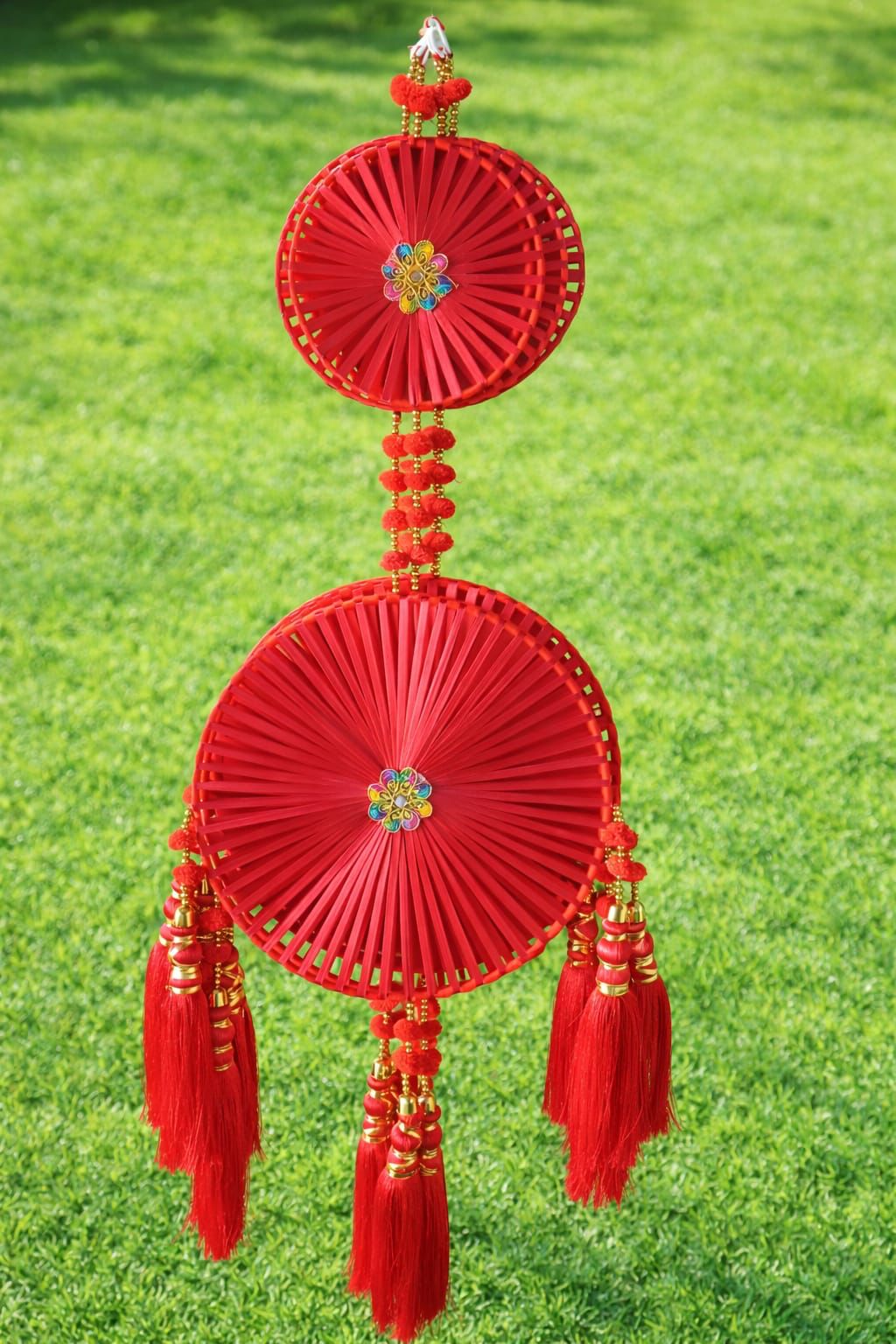 Red tasseled hanging pankha decor piece