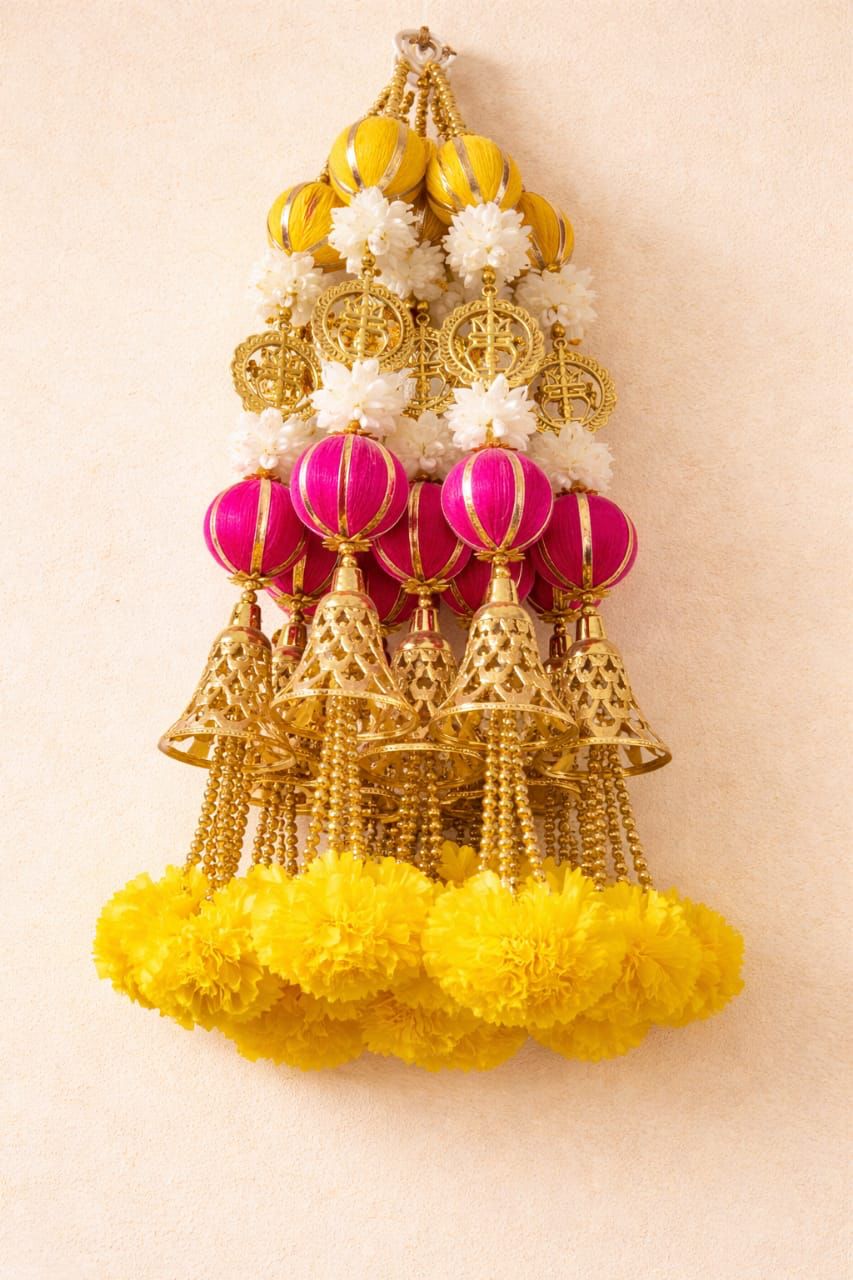Gold bell hanging with pink yellow and white flowers