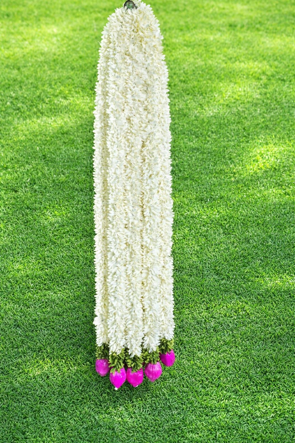 White artificial flower garland with pink flower accents